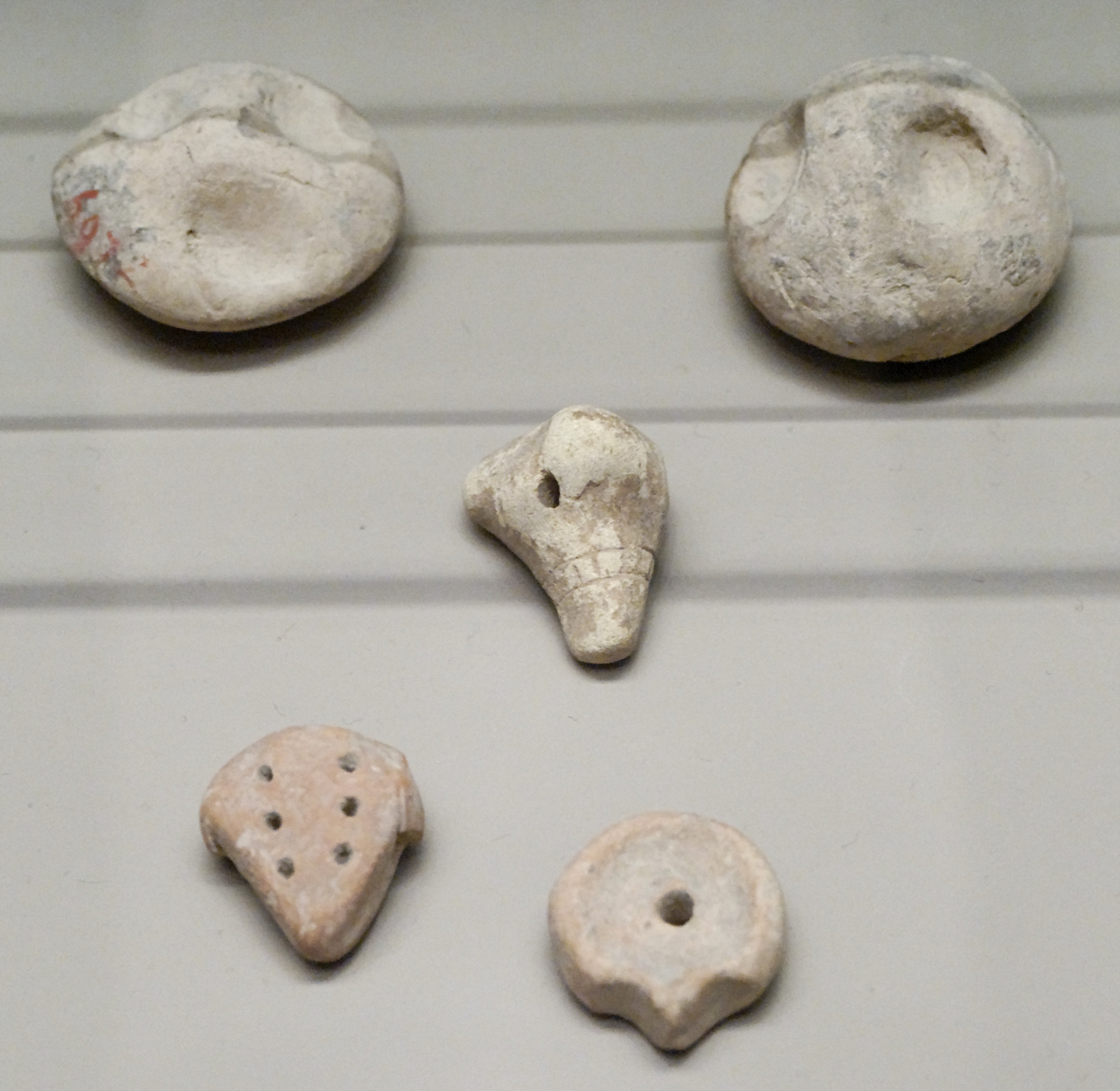 Conjunto de pequeñas fichas de contabilidad de arcilla expuestas en el Museo del Louvre.